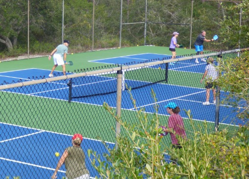People playing pickle ball on the courts.