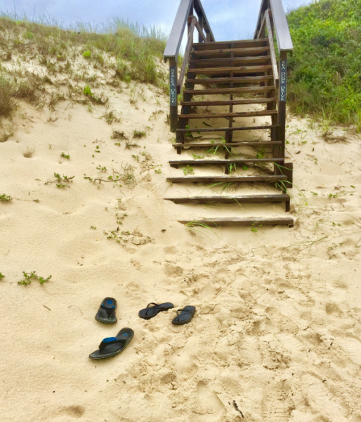 Easy beach access, vacationers leave their sandals behind in the sand.
